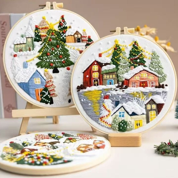 Three embroidered Christmas scenes in hoops on a neutral background