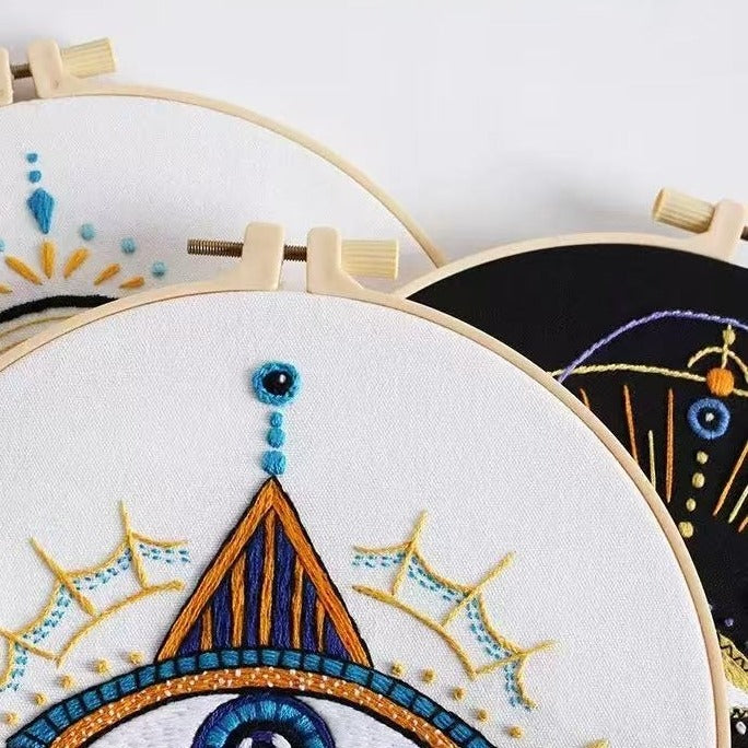 Embroidery hoops with colorful geometric embroidery on a white background