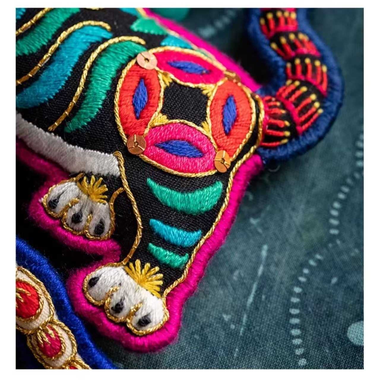 close up a Colorful embroidered tiger on a denim background
