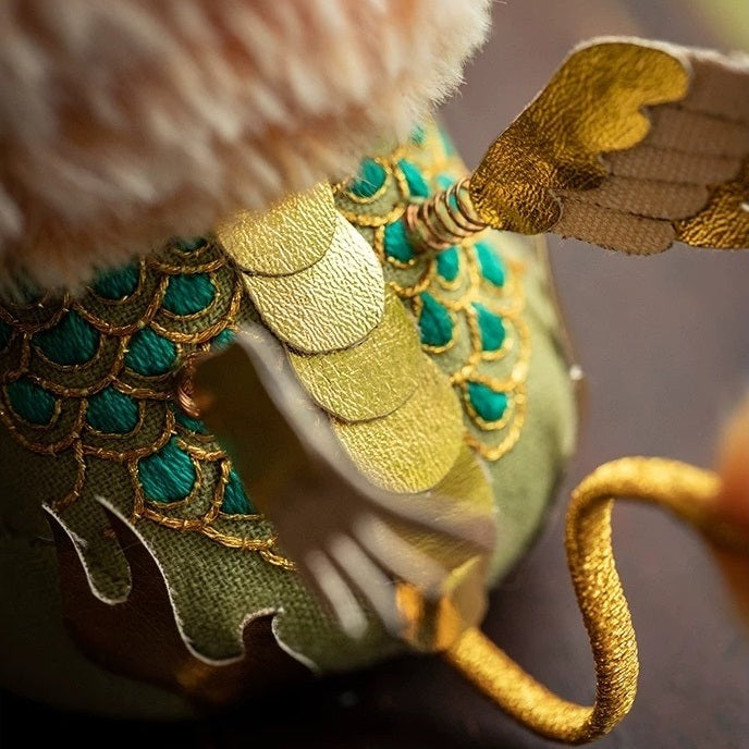 Close-up of the back of embroidered Chinese beast Kylin doll with spring-loaded golden wings and green stitches details