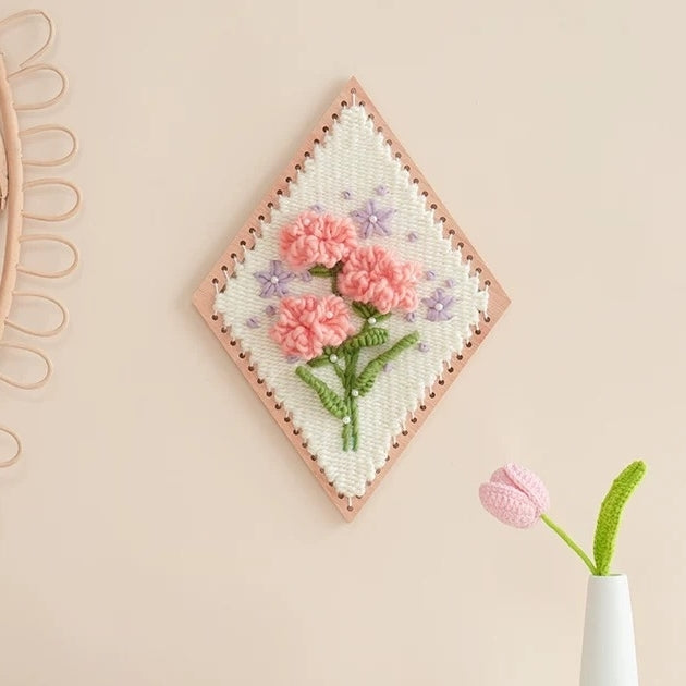 image displaying a finished Carnation Flower Weaving Loom Kit hanging on wall as a decoration