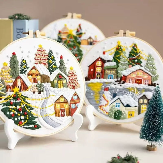 Embroidery hoops with Christmas winter village scenes on a neutral background