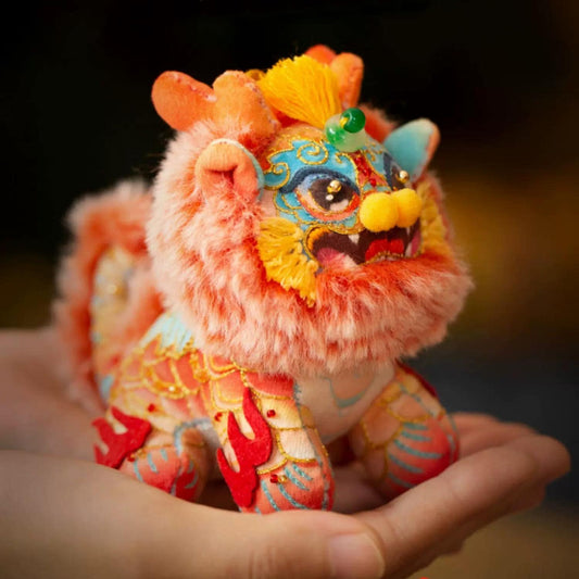 A hand holding a colorful, fluffy DIY embroidery kit in the shape of a mythical creature Kylin, with a vibrant and ornate design.