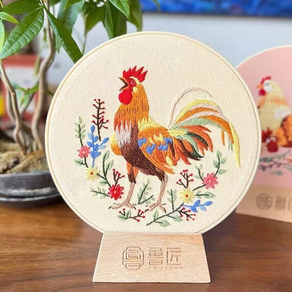 Embroidered rooster on a circular wooden stand with plants in the background