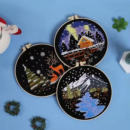 Three embroidery hoops with festive winter-themed designs on a blue background