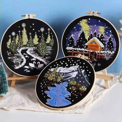 Three embroidery hoops with winter-themed designs on a blue background