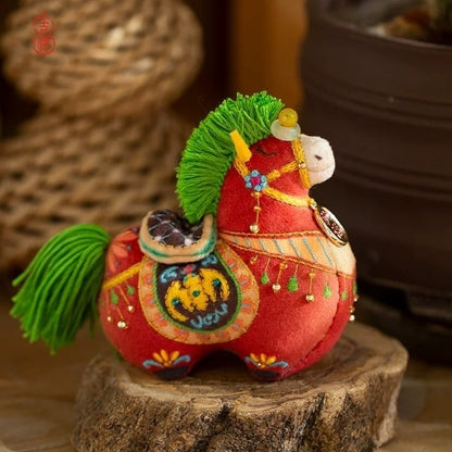 Red horse embroidered fabric doll with colorful details and ancient Chinese elements on a wooden stump