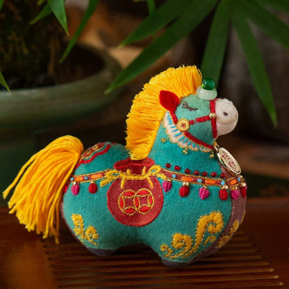 Decorative horse plush toy with colorful embroidery on a wooden surface.