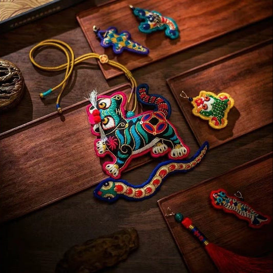 Colorful embroidered tiger and five poisons creatures decorations on a wooden table