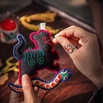 Handmade tiger and snake toy with colorful details being embroidered 